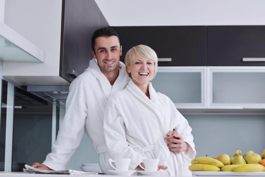 happy young couple have fun in  modern kitchen indoor  while preparing fresh fruits and vegetables food salad