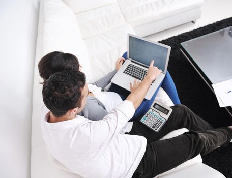 joyful couple relax and work on laptop computer at modern living room indoor home