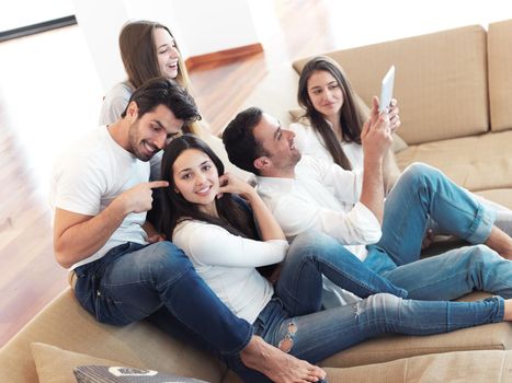 group of friends taking selfie photo with tablet at modern home indoors