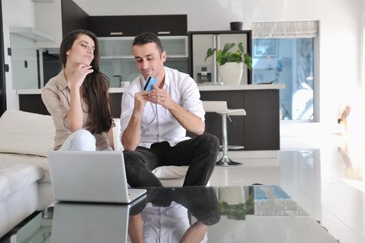 joyful couple relax and work on laptop computer at modern living room indoor home