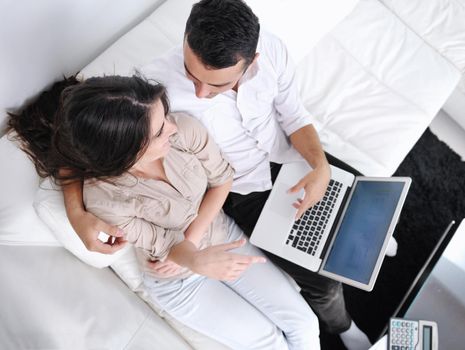 joyful couple relax and work on laptop computer at modern living room indoor home