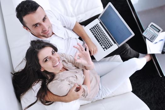 joyful couple relax and work on laptop computer at modern living room indoor home