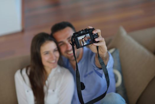 happy young  couple playing with digital camera at home