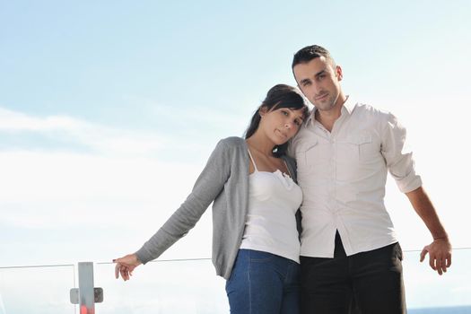 happy young couple in love have romance  relax on balcony outdoor with ocean and blue sky in background