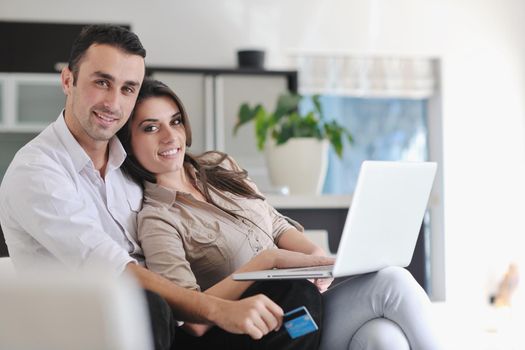 joyful couple relax and work on laptop computer at modern living room indoor home