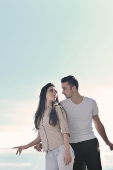 happy young couple relax on balcony outdoor with ocean and blue sky in background