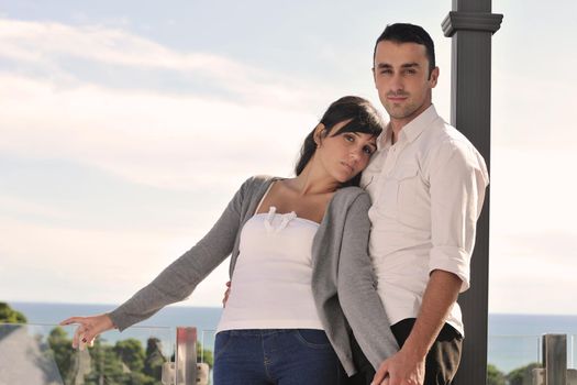 happy young couple in love have romance  relax on balcony outdoor with ocean and blue sky in background