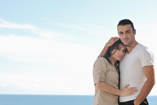 happy young couple in love have romance  relax on balcony outdoor with ocean and blue sky in background