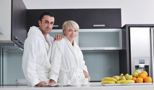 happy young couple have fun in  modern kitchen indoor  while preparing fresh fruits and vegetables food salad