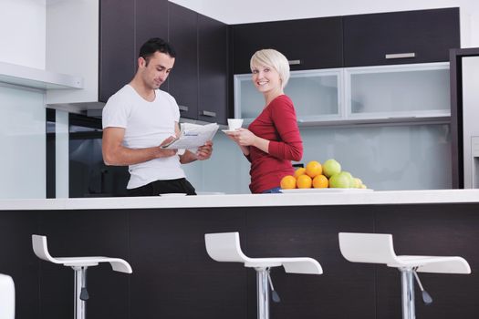 young family couple read newspaper at kitchen in morning with  fresh breakfast  fruits food and coffee drink on table