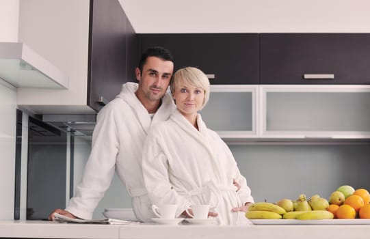 happy young couple have fun in  modern kitchen indoor  while preparing fresh fruits and vegetables food salad