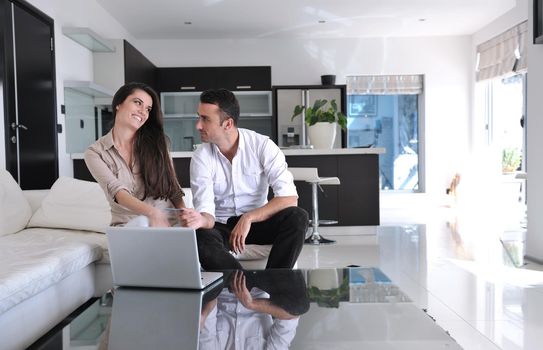 joyful couple relax and work on laptop computer at modern living room indoor home