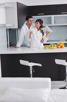 happy young couple have fun in  modern kitchen indoor  while preparing fresh fruits and vegetables food salad