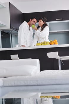 happy young couple have fun in  modern kitchen indoor  while preparing fresh fruits and vegetables food salad