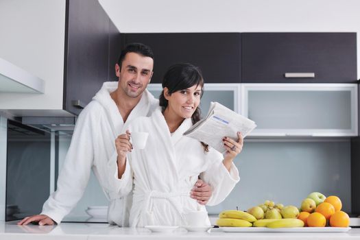 young family couple read newspaper at kitchen in morning with  fresh breakfast  fruits food and coffee drink on table