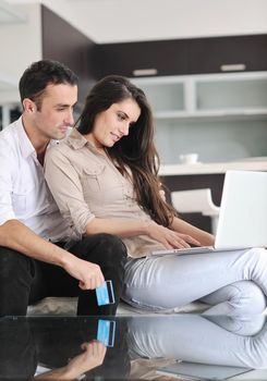 joyful couple relax and work on laptop computer at modern living room indoor home