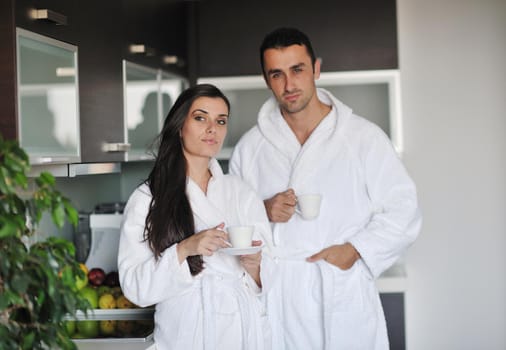 Young love couple taking fresh morning cup of coffee in the modern appartment