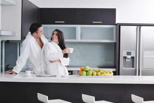 happy young couple have fun in  modern kitchen indoor  while preparing fresh fruits and vegetables food salad