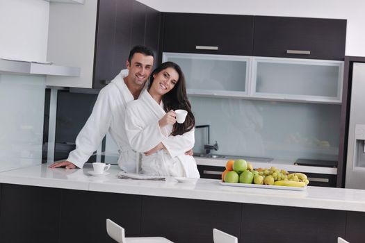 happy young couple have fun in  modern kitchen indoor  while preparing fresh fruits and vegetables food salad