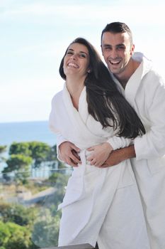 happy young couple relax on balcony outdoor with ocean and blue sky in background