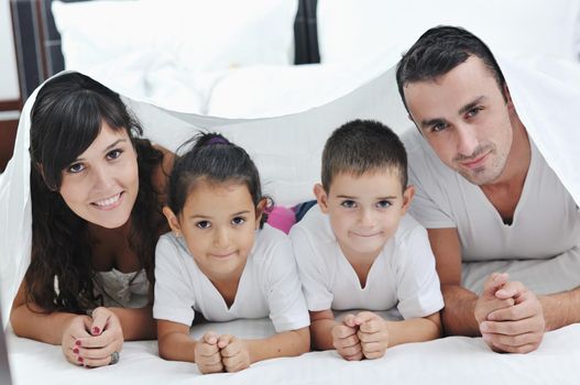 happy young Family in their bedroom have fun and play in bed