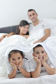 happy young Family in their bedroom have fun and play in bed