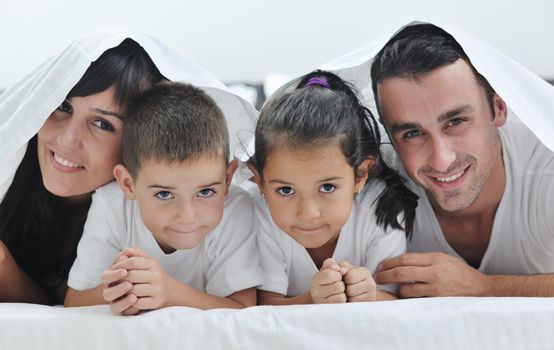 happy young Family in their bedroom have fun and play in bed