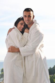 happy young couple relax on balcony outdoor with ocean and blue sky in background