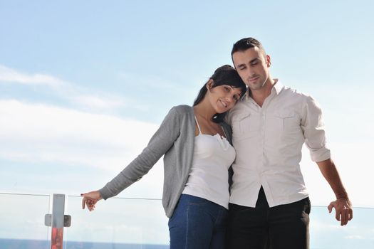 happy young couple in love have romance  relax on balcony outdoor with ocean and blue sky in background