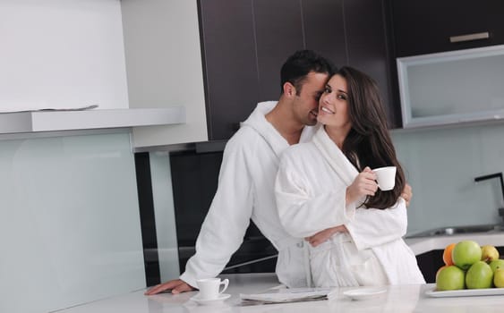 happy young couple have fun in  modern kitchen indoor  while preparing fresh fruits and vegetables food salad