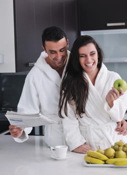 happy young couple have fun in  modern kitchen indoor  while preparing fresh fruits and vegetables food salad