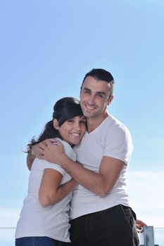 happy young couple relax on balcony outdoor with ocean and blue sky in background