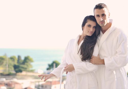 happy young couple relax on balcony outdoor with ocean and blue sky in background