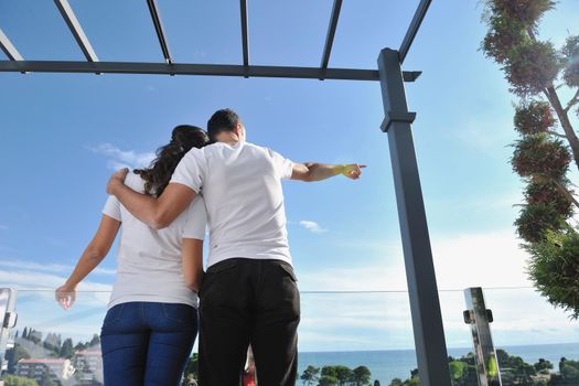 happy young couple in love have romance  relax on balcony outdoor with ocean and blue sky in background