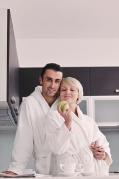 happy young couple have fun in  modern kitchen indoor  while preparing fresh fruits and vegetables food salad