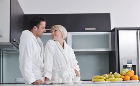 happy young couple have fun in  modern kitchen indoor  while preparing fresh fruits and vegetables food salad