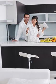 happy young couple have fun in  modern kitchen indoor  while preparing fresh fruits and vegetables food salad