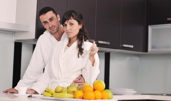 happy young couple have fun in  modern kitchen indoor  while preparing fresh fruits and vegetables food salad