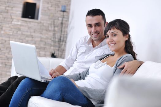 joyful couple relax and work on laptop computer at modern living room indoor home