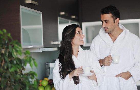 Young love couple taking fresh morning cup of coffee in the modern appartment