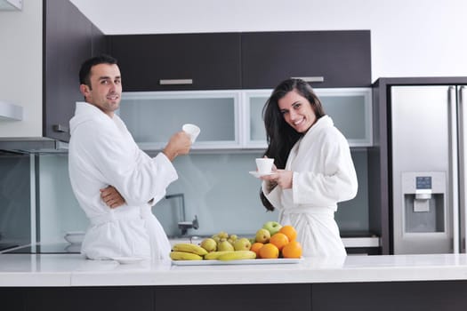 happy young couple have fun in  modern kitchen indoor  while preparing fresh fruits and vegetables food salad