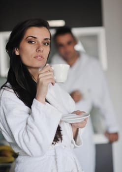 Young love couple taking fresh morning cup of coffee in the modern appartment