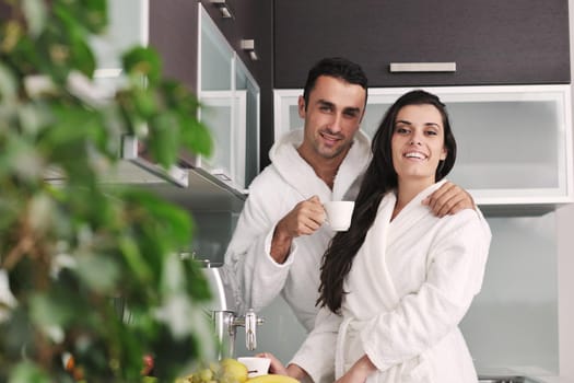 Young love couple taking fresh morning cup of coffee in the modern appartment