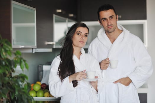 Young love couple taking fresh morning cup of coffee in the modern appartment