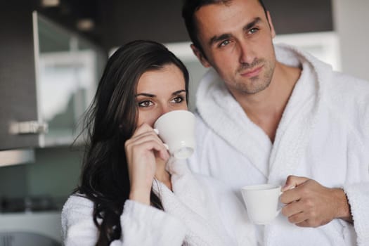 Young love couple taking fresh morning cup of coffee in the modern appartment