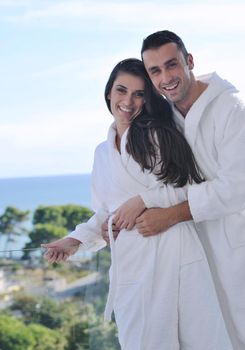 happy young couple relax on balcony outdoor with ocean and blue sky in background