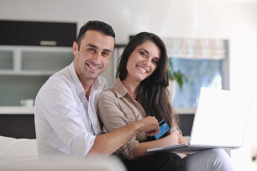 joyful couple relax and work on laptop computer at modern living room indoor home