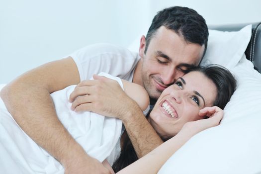 happy young healthy people  couple have good time in their bedroom make love and sleep