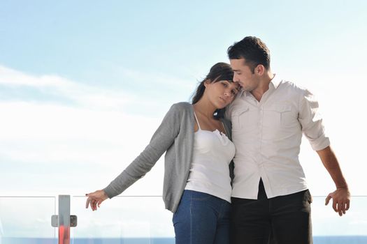 happy young couple in love have romance  relax on balcony outdoor with ocean and blue sky in background