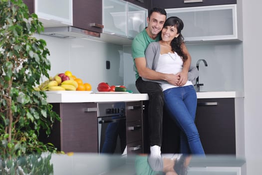 happy young couple have fun in  modern kitchen indoor  while preparing fresh fruits and vegetables food salad